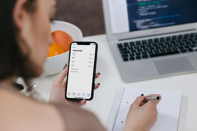 A woman checking voicemail on an iPhone.